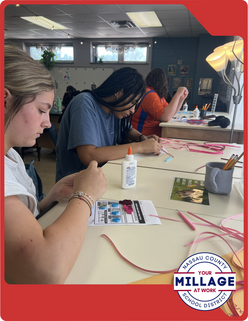 Students are learning to roll, shape, and arrange thin strips of paper into intricate designs, turning simple materials into beautiful works of art.