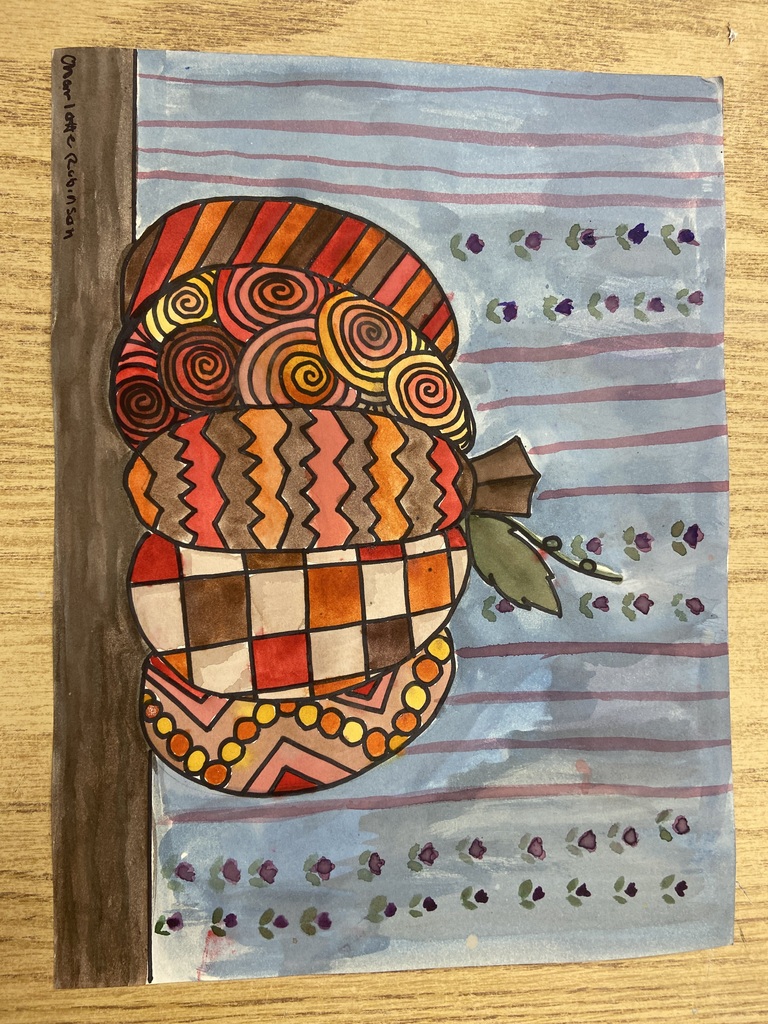 Colorful student artwork featuring a patterned acorn filled with geometric and spiral designs against a blue decorative background.
