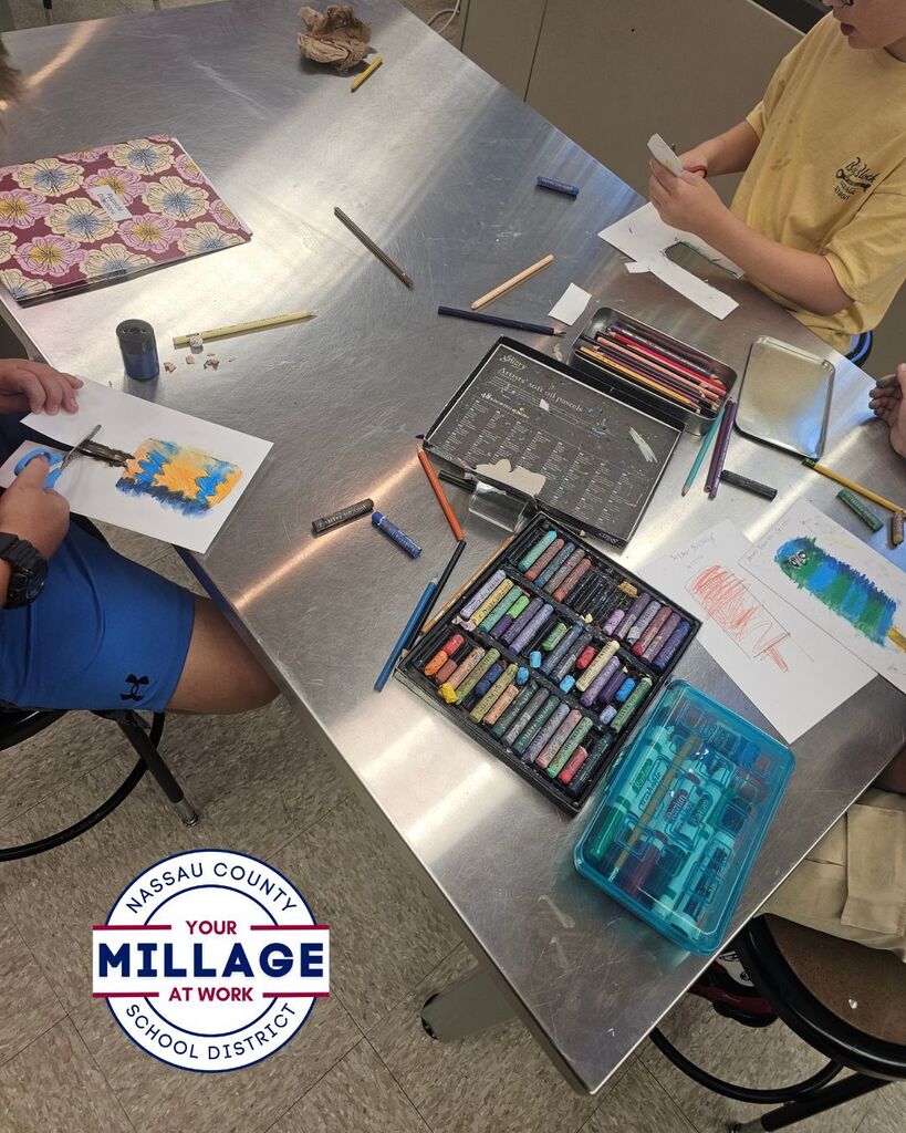 Student holds a colorful oil pastel artwork of a popsicle mounted on green construction paper in an art classroom. Additional images show student artwork displayed on a hallway wall and students using oil pastels at a classroom table while practicing blending and coloring techniques.
