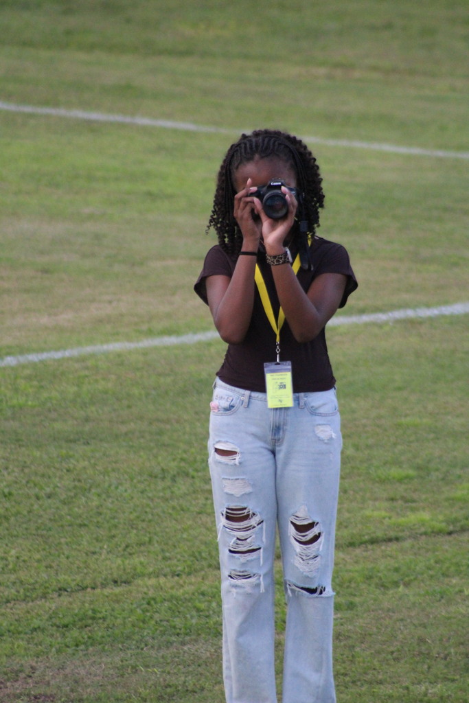 student taking photo on football field