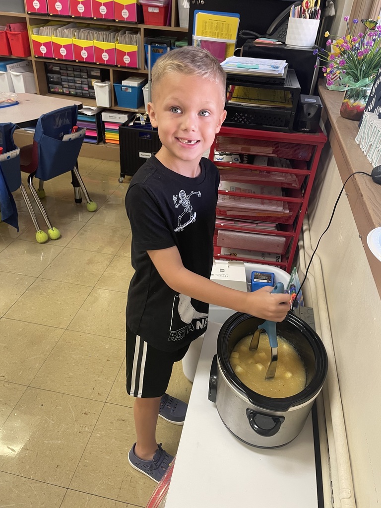 boy stirring a pot of apples