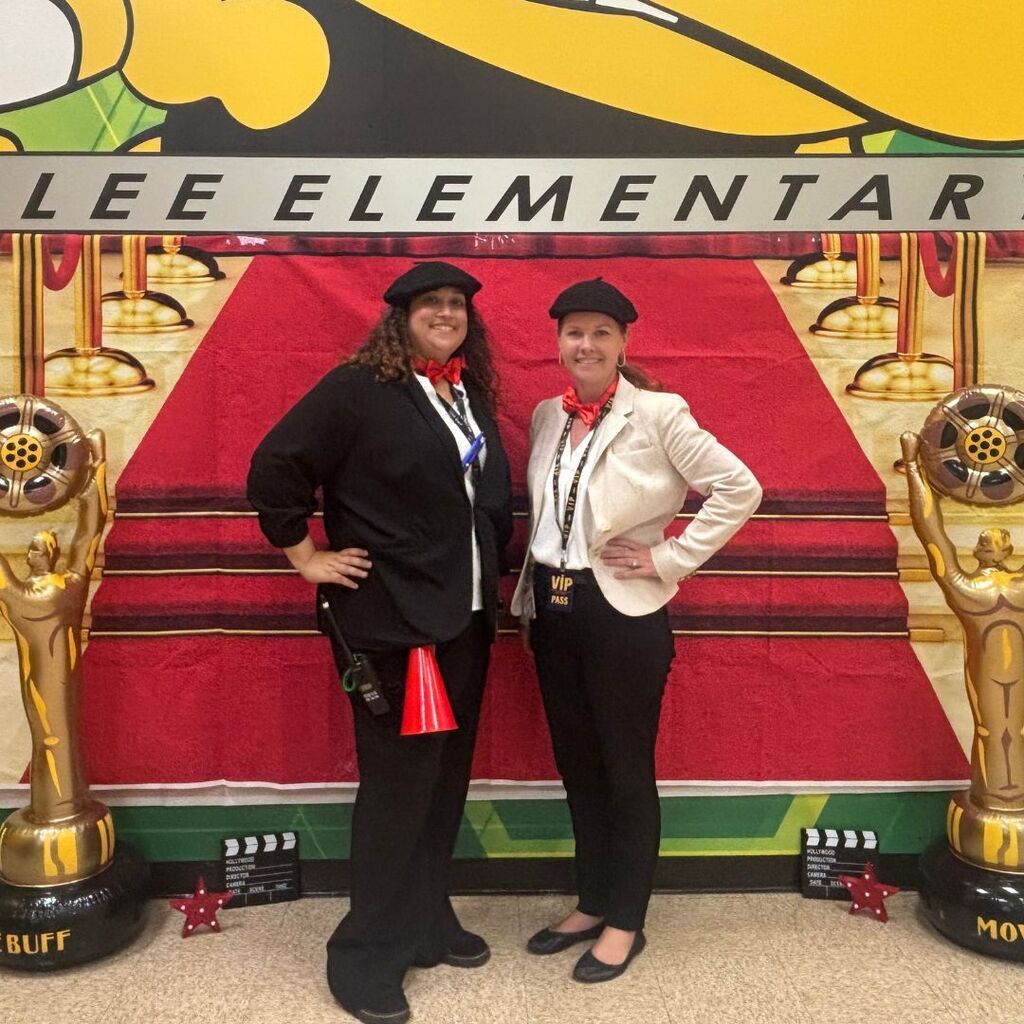 Ms. Porter and Ms. Hays pose in front of red carpet movie decorations