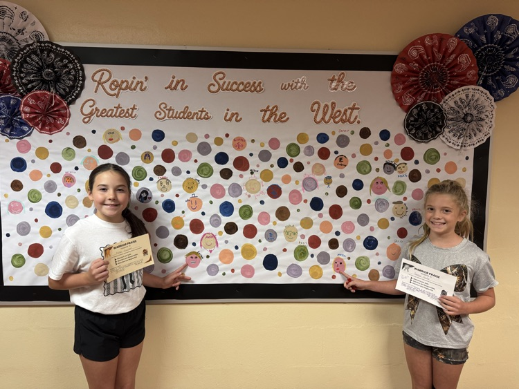 Students proudly point to their colorful self-portrait dots displayed as part of Warrior Praise. Each dot celebrates a CIS Warrior being Respectful, Responsible, and Safe.