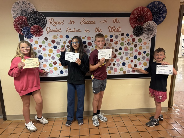 Students proudly point to their colorful self-portrait dots displayed as part of Warrior Praise. Each dot celebrates a CIS Warrior being Respectful, Responsible, and Safe.