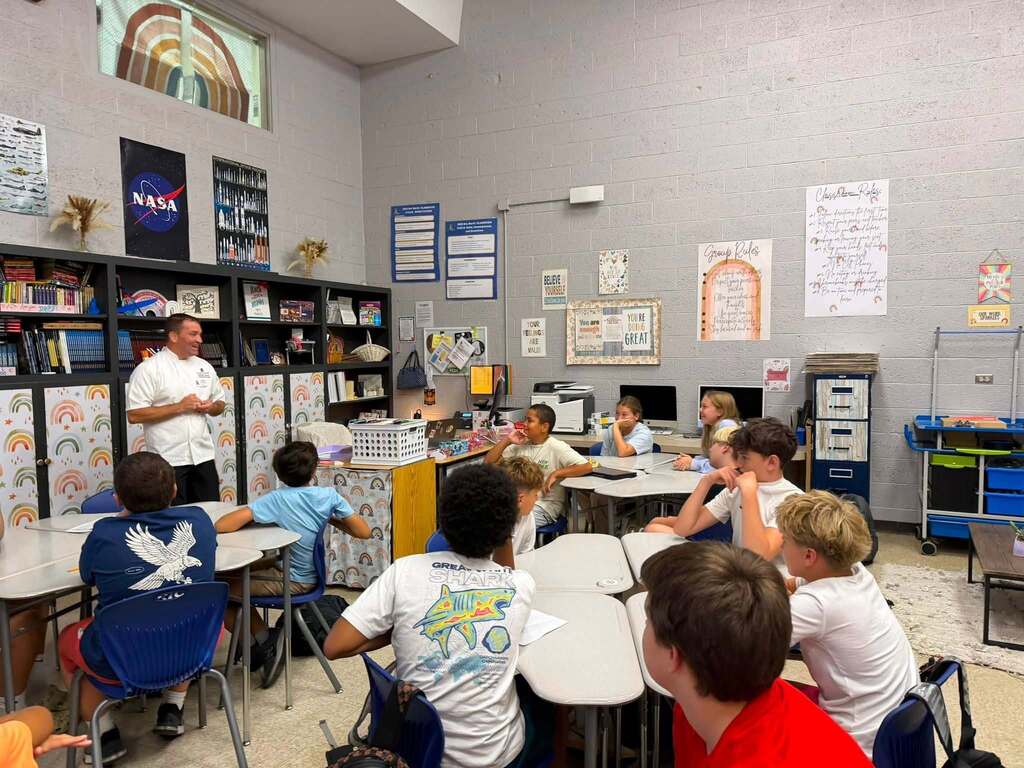A hospitality industry professional speaks with Fernandina Beach Middle School students during a classroom career exploration presentation about hospitality and tourism.