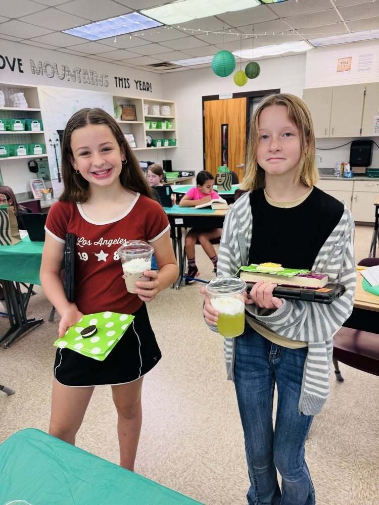 Two Callahan Intermediate School students hold books and drinks during the coffee shop-themed STARBOOKS literacy activity.