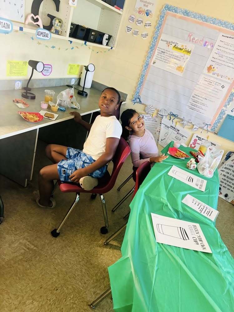 Two Callahan Intermediate School students sit at coffee shop-themed classroom tables during the STARBOOKS literacy and reading activity.