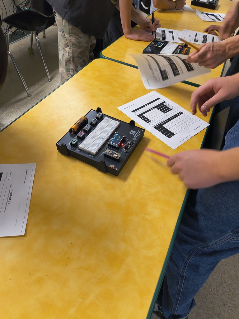 Yulee High School students work at sensor exploration stations during a hands-on artificial intelligence curriculum lab, recording observations from AHA! technology boards.