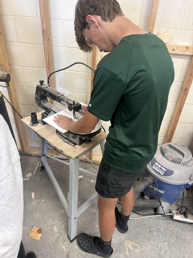 student using a saw in building construction