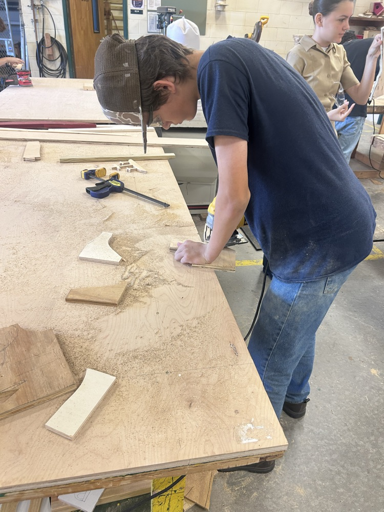 student using a saw in building construction