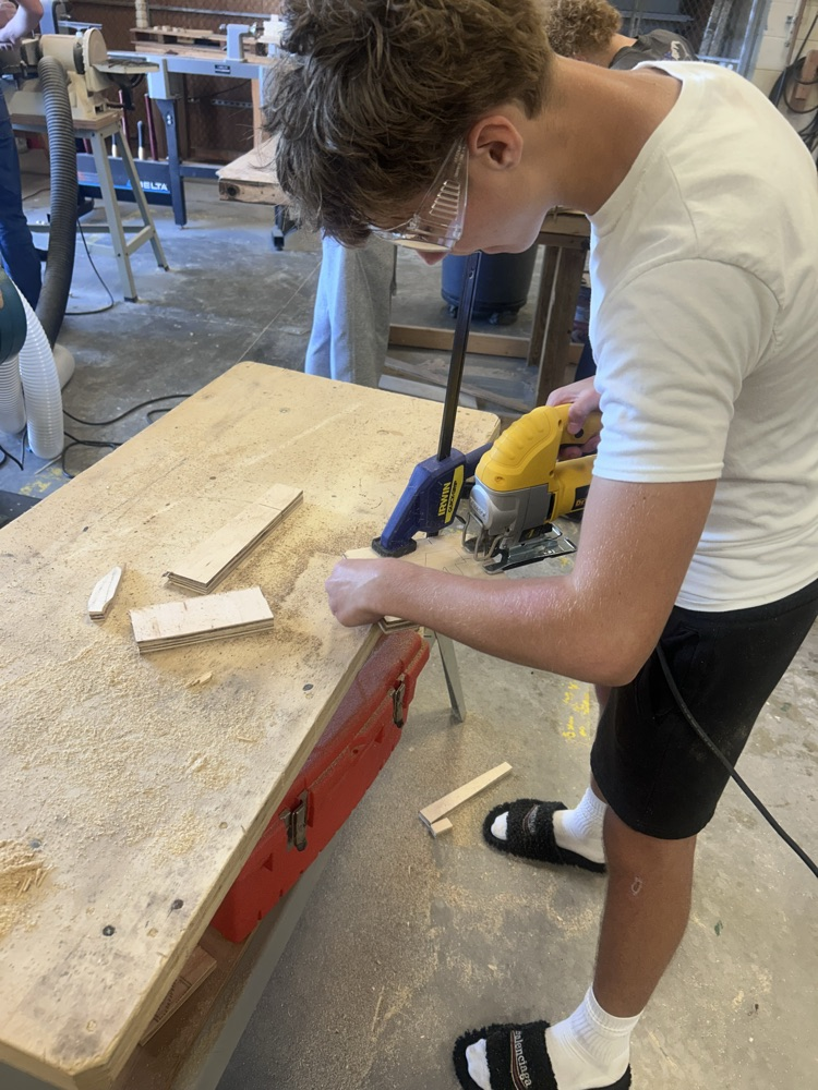 student using a saw in building construction