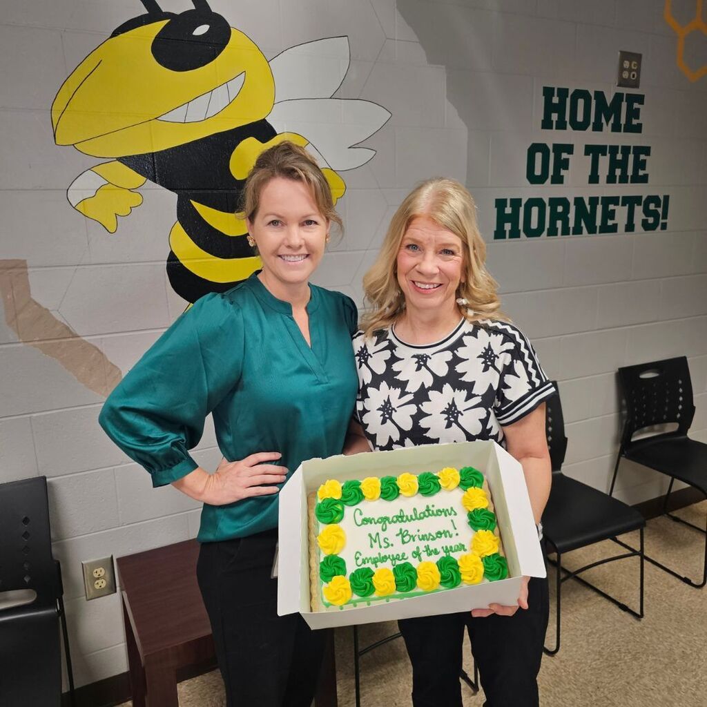 Ms Brinson and Ms. Hays holding a cake to celebrate school related employee of the year.