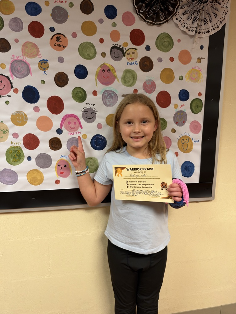 Students who received Warrior praise pointing towards their self-portrait dots.