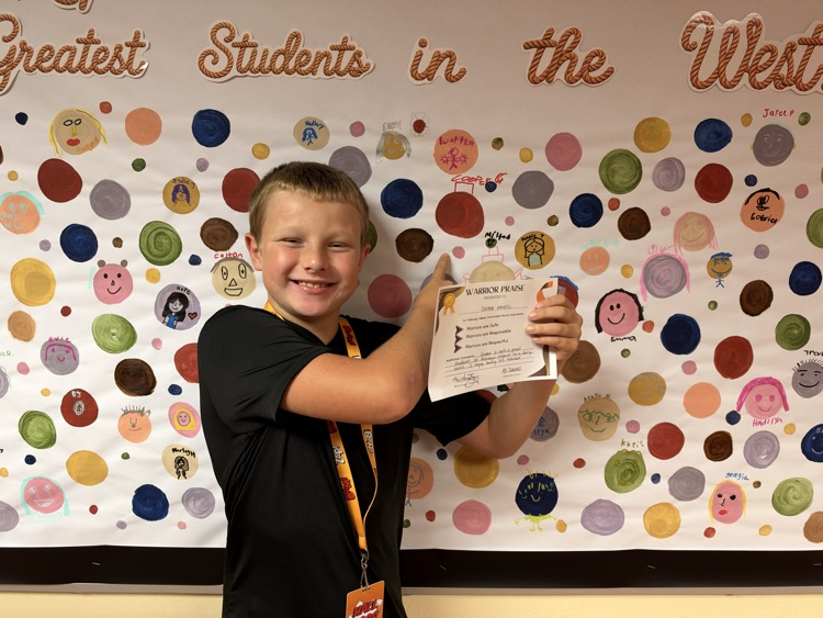 Students who received Warrior praise pointing towards their self-portrait dots