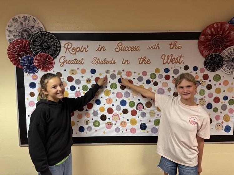 Students who received Warrior praise pointing towards their self-portrait dots