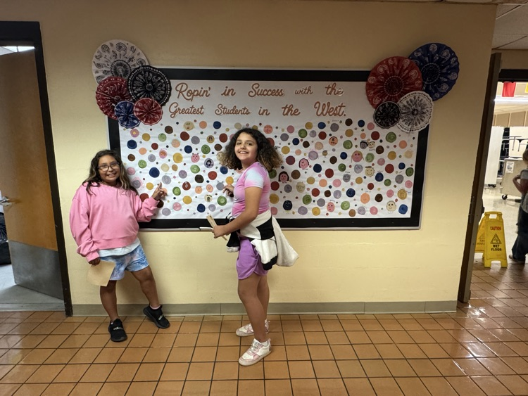 Students who received Warrior praise pointing towards their self-portrait dots