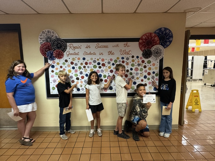 Students who received Warrior praise pointing towards their self-portrait dots