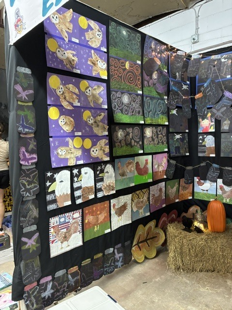 Student art of different medias displayed at the NEFL Fair. Eagles, chickens, and owls are depicted.