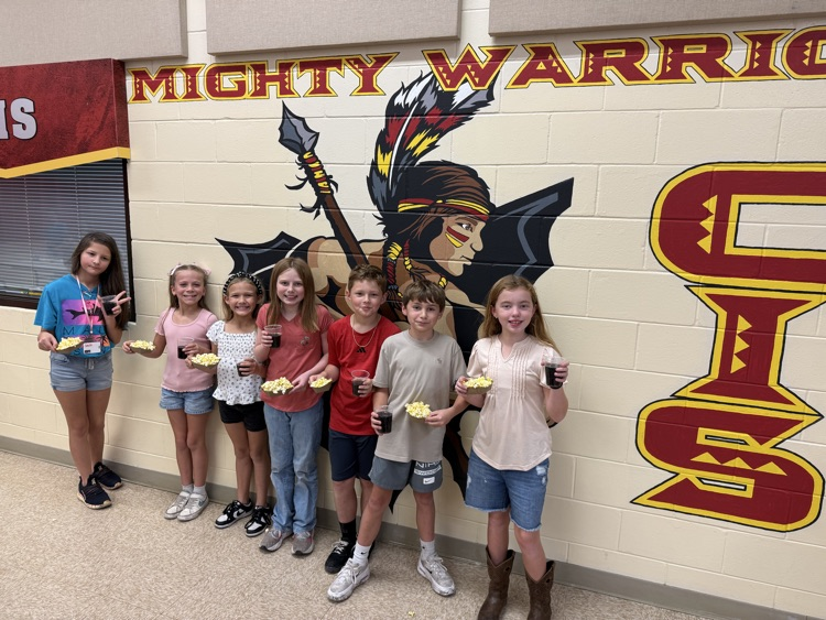 A group of students are posing with their popcorn and soda.