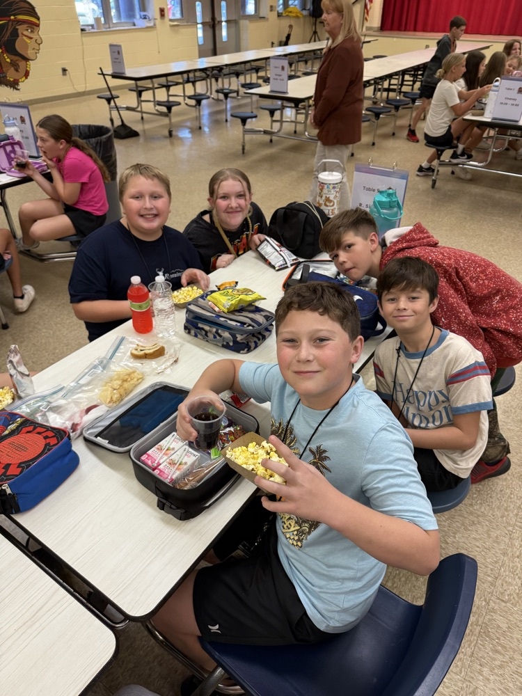 A group of students are posing with their popcorn and soda
