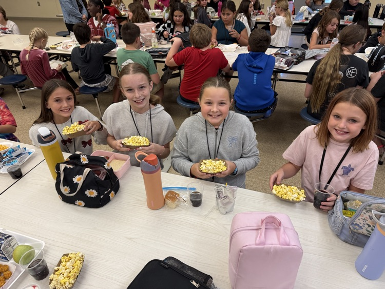 A group of students are posing with their popcorn and soda