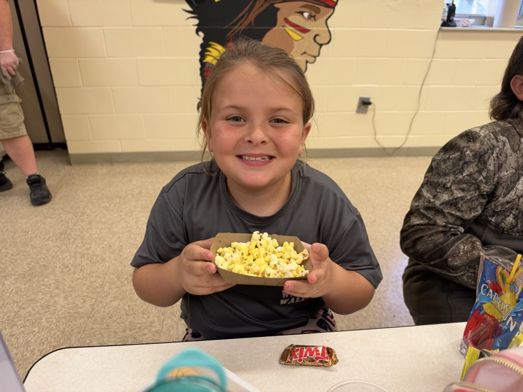 A student is showing off her AR popcorn prize.