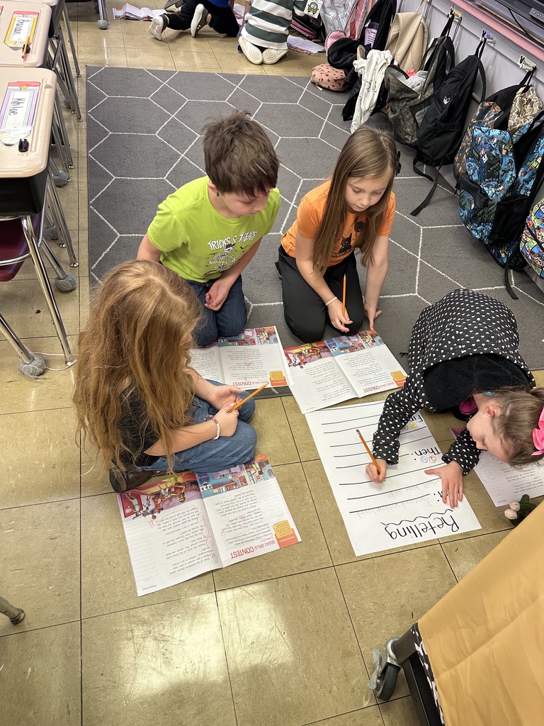 students working together on the floor to fill in a retelling chart