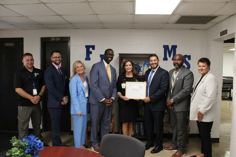 The Commissioner of Education stands with district leaders and Fernandina Beach Middle School Principal Dr. Anna Crawford as she receives the MTSS Recognized Schools Award.