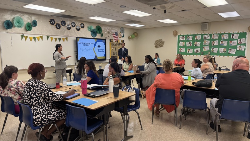 Dr. Misty Mathis greets AP Academy attendees alongside director Mr. Bryce Cubbal.