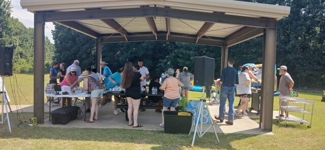 group of people gathered grilling food