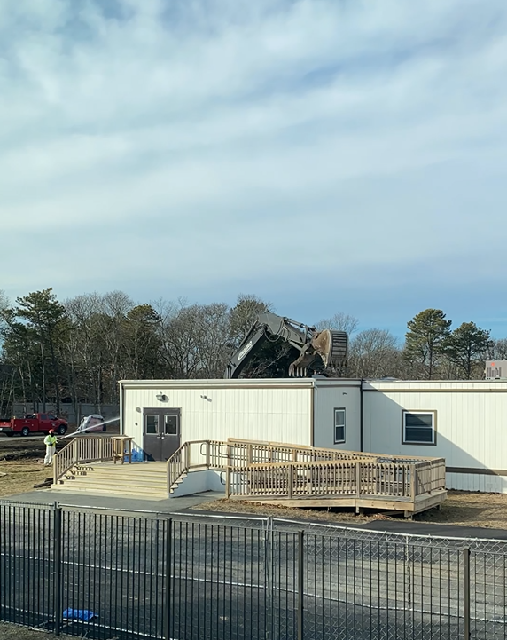 Image of an excavator demolishing the modular buildings