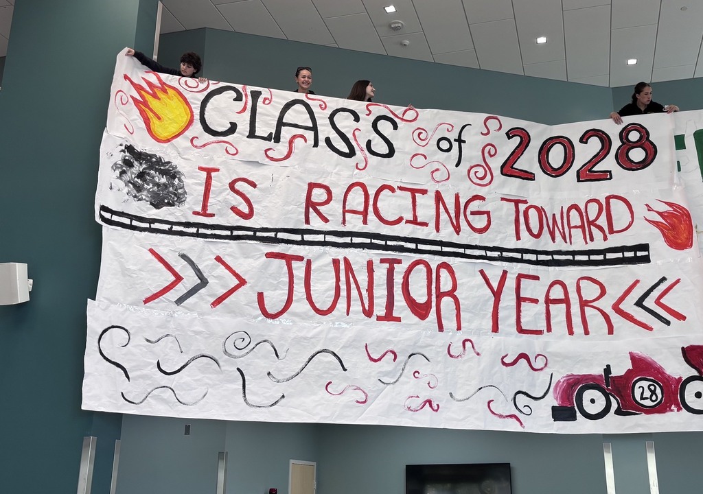 Sophomore Class Pep Rally Banner - red and black text "Class of 2028 is racing towards junior year" with flames and a race car.