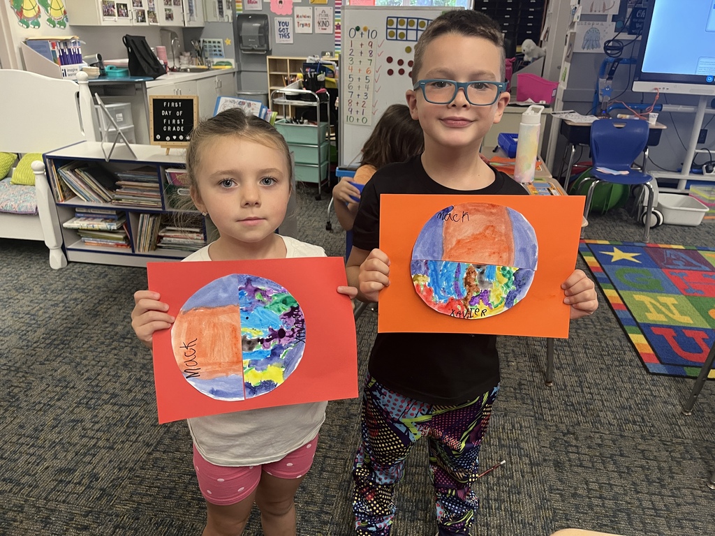students hold artwork 