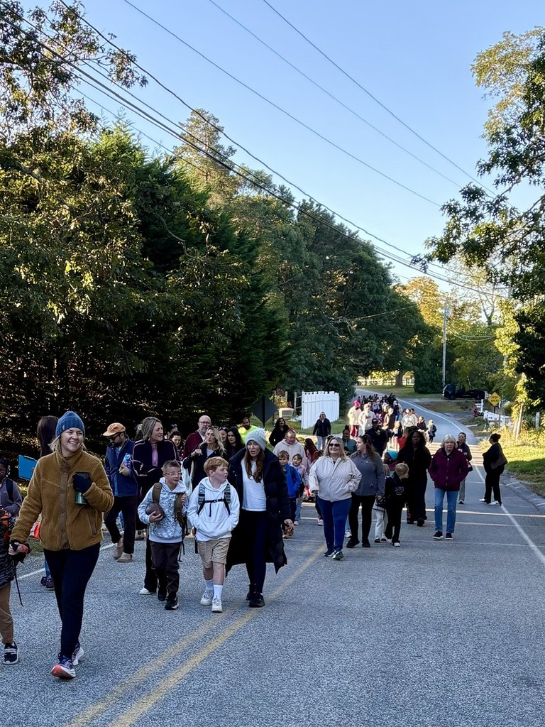 students, families, and staff walking down the street to school