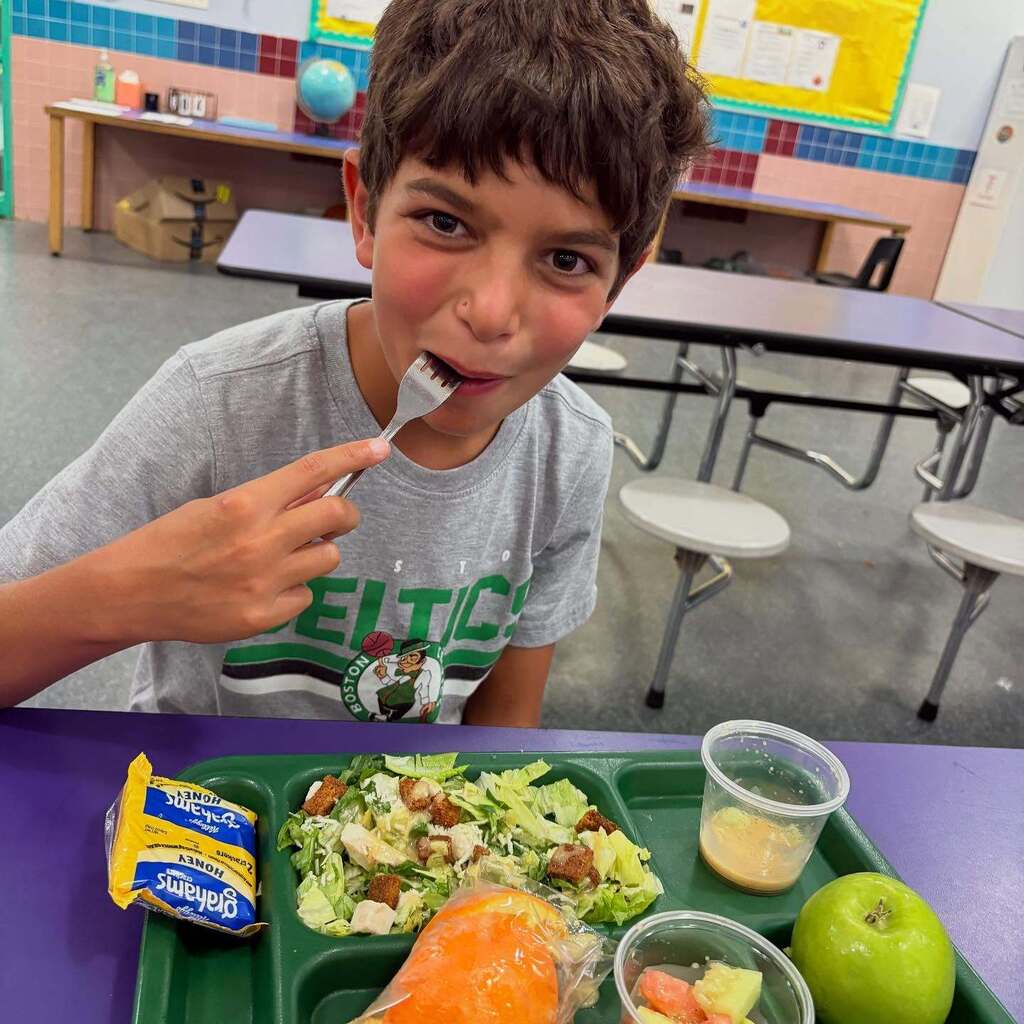 student eats lunch in cafeteria