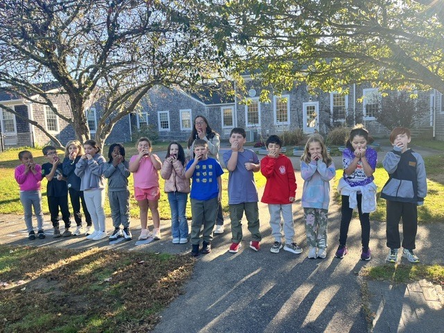 students biting into apples outside