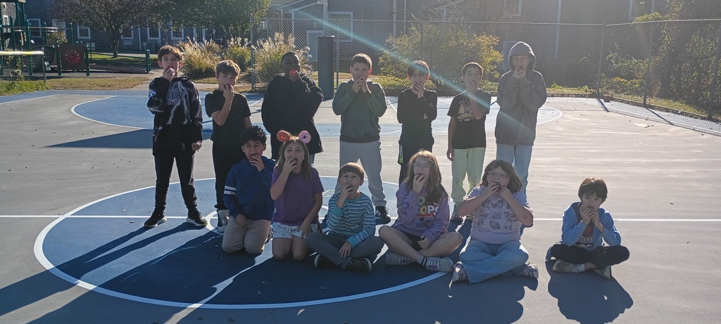 students biting into apples outside