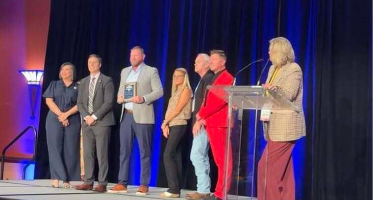 Administrators pose on stage to receive award