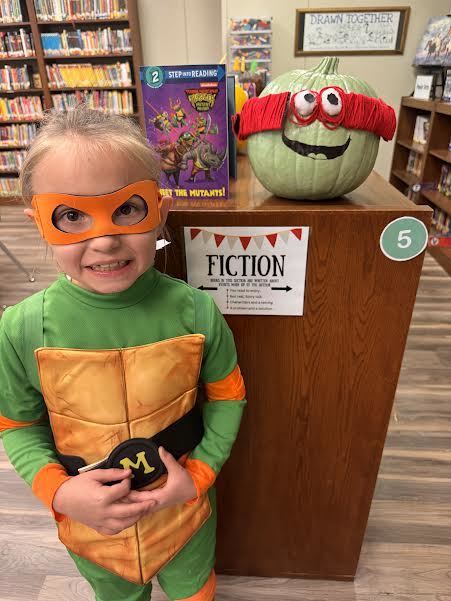 1st grade students with decorated pumpkins.