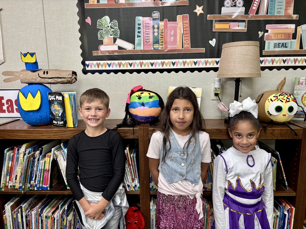 1st grade students with decorated pumpkins.