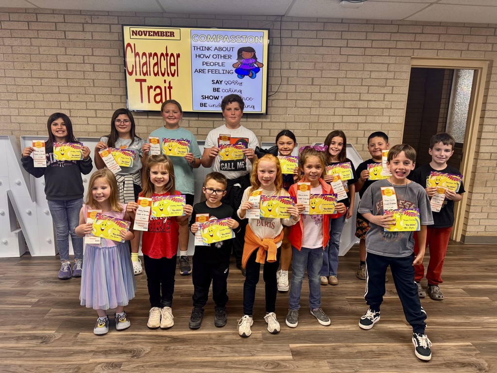 Students standing in two rows holding their personalized student of the week certificate and a whataburger coupon.