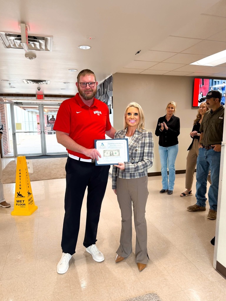 Mr. Granger shaking hands with a member of the commerce and holding a sign with our first $1 bill with them. 
