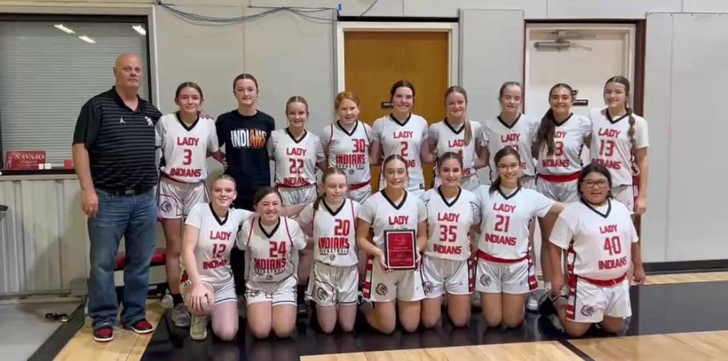jr high girls team lined up in two rows on the court