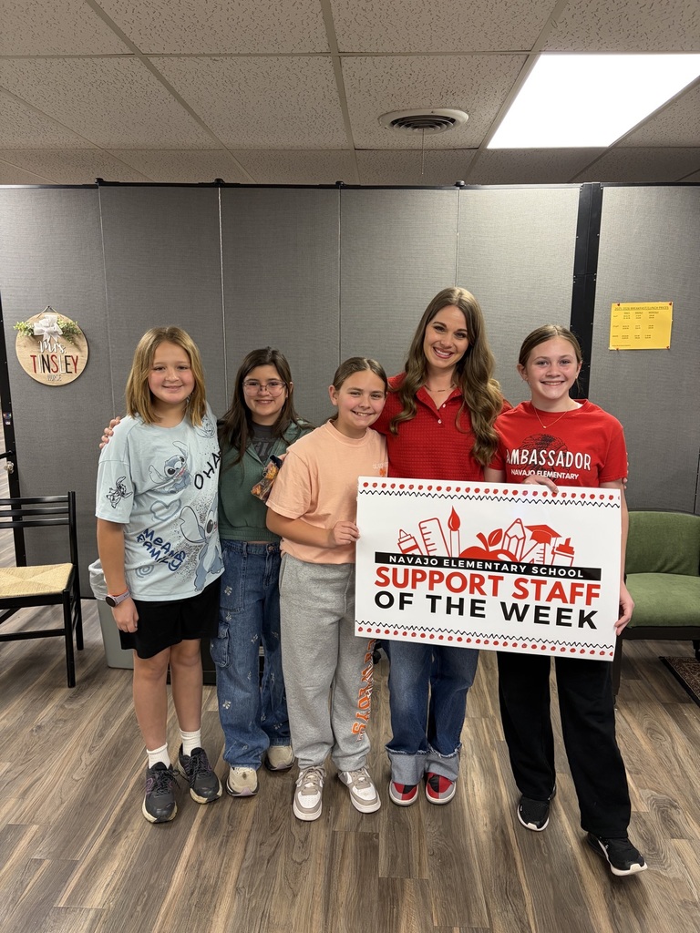 Mrs. Tinsley standing with 4 6th grade girls holding a sign that says support staff of the week