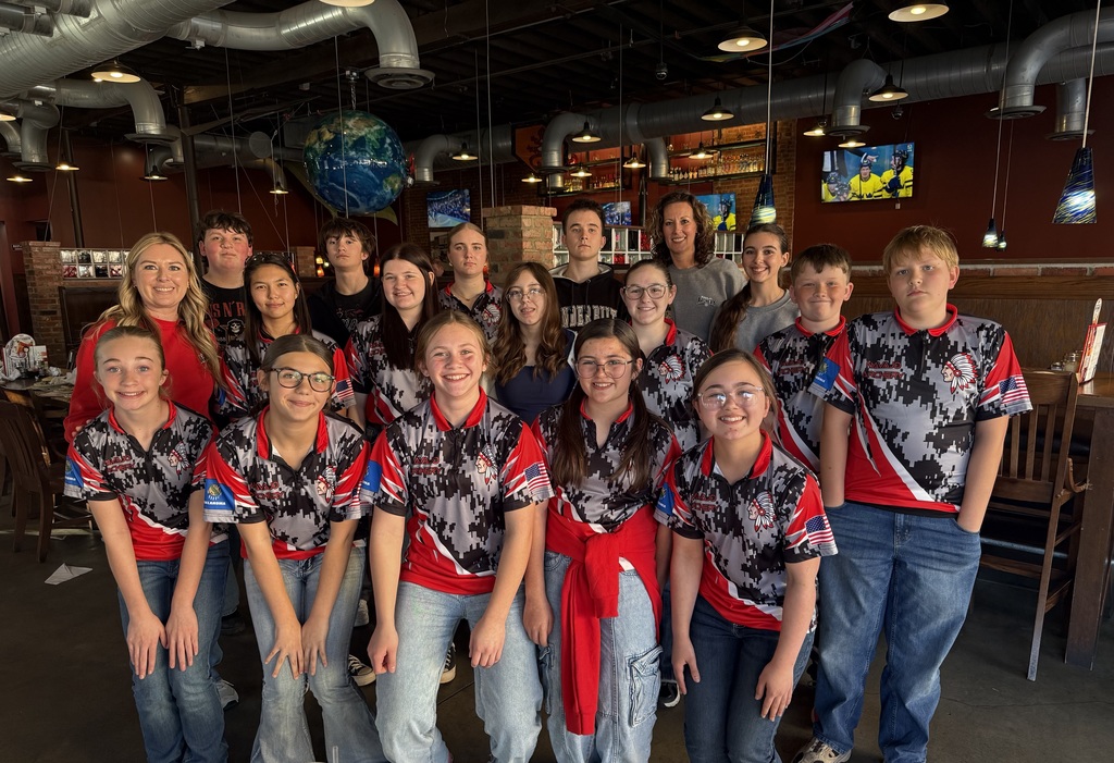 Archery team posing inside a pizza resturant