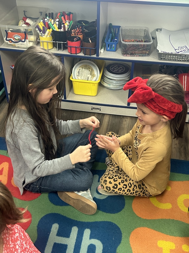students practicing flossing between their friends fingers 
