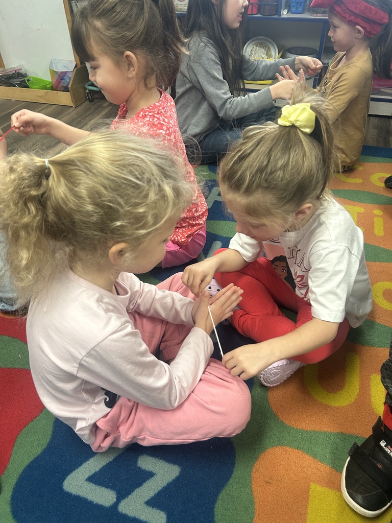 Students practicing flossing between their friends fingers