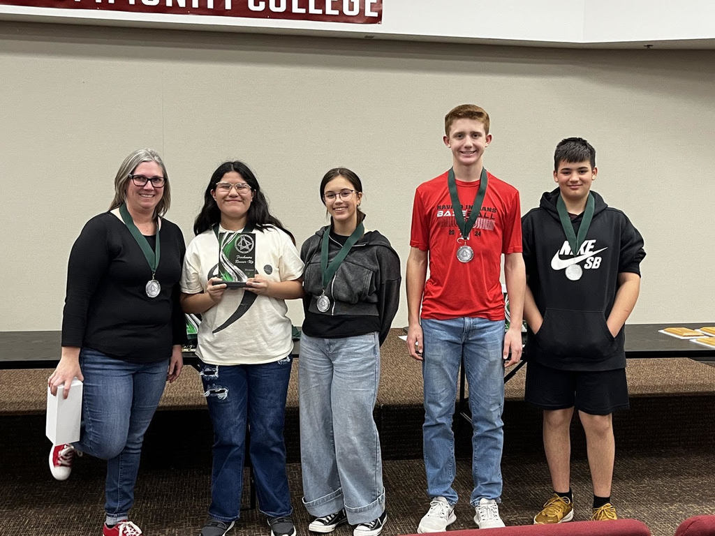 Academic team and coach Janelle pikinich lined up with an award and medals