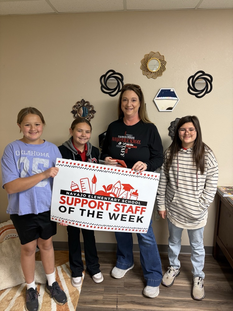 Mrs Ferrell with 3 6th grade students holding a banner