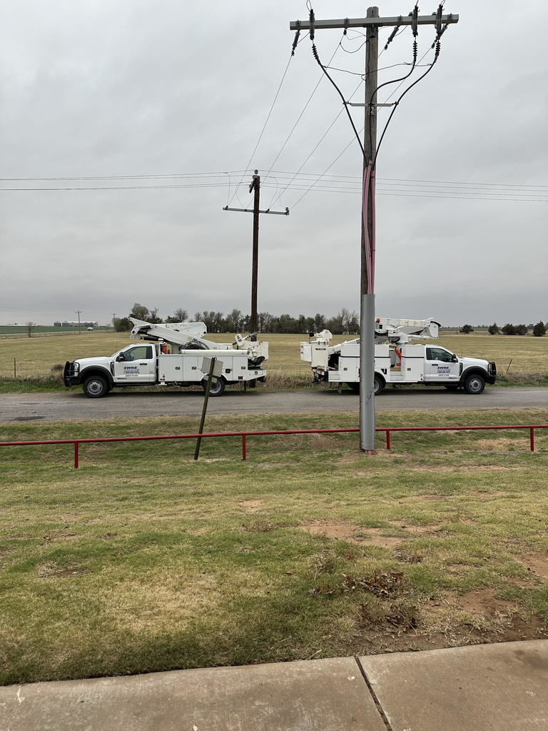 Two SWRE trucks parked by the school electric lines